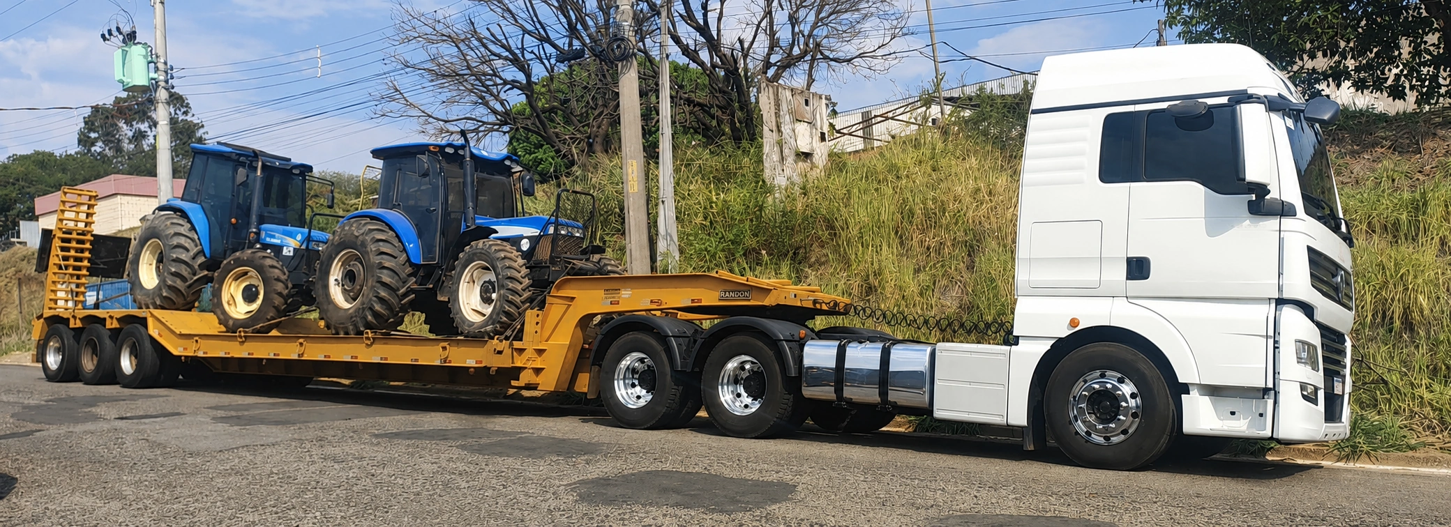 Caminhão SLE Transporte em operação com máquina pesada